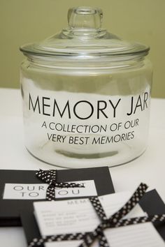 a glass jar sitting on top of a table next to some cards and tags in front of it