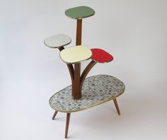 three tiered table with four different colored tables on each side and one standing upright