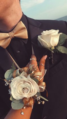 a close up of a person wearing a suit and tie with flowers in his lapel