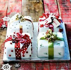 three wrapped presents sitting on top of a wooden table next to snowflakes