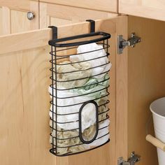 a kitchen cabinet door is open and has a wire basket with money in it hanging from the drawer