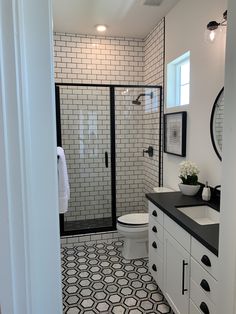 a bathroom with black and white tile on the floor