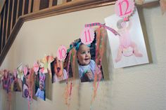 a baby's first birthday photo hanging on the wall with streamers and decorations