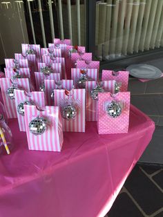 pink and white striped bags with silver ornaments on them sitting on a table in front of a window