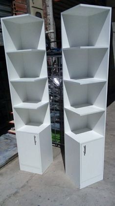 two white shelving units sitting next to each other on top of a cement floor