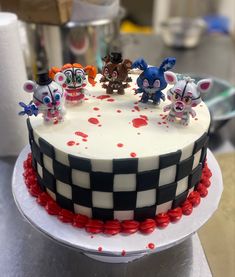 a cake decorated with five little mouses on top of it and red sprinkles