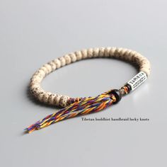 the beaded bracelet has a name tag on it and is decorated with multicolored beads