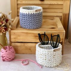 two crochet baskets sitting on top of a wooden box