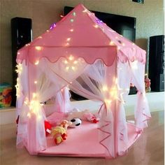 a pink princess bed with white curtains and lights