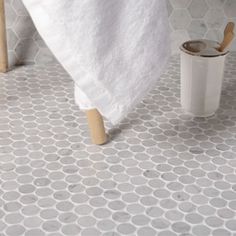 a bathroom with white and gray tile on the floor