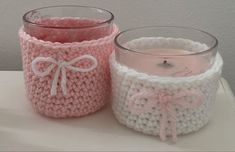 two crocheted jars sitting next to each other on top of a white table