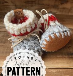 two crocheted baby shoes are sitting on a wooden floor