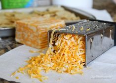 shredded cheese is being grated in to a slice of bread on a napkin next to other food items