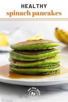 a stack of green pancakes sitting on top of a white plate next to some bananas