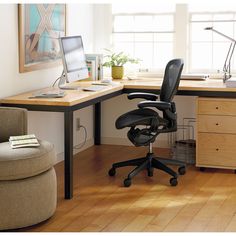 an office chair sits in front of a computer desk