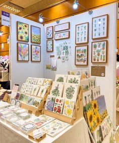 a table topped with lots of cards and pictures next to a wall covered in framed pictures