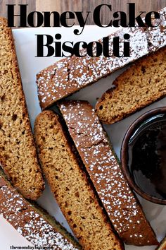 homemade honey cake biscotti on a plate with chocolate sauce and powdered sugar