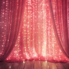 a red curtain with lights on it in front of a wooden floor and wood floors