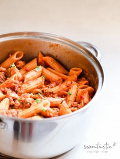 a pot filled with pasta and sauce on top of a stove