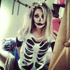 a woman in skeleton makeup taking a selfie