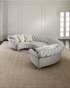 a large sectional couch sitting on top of a rug in front of a white wall