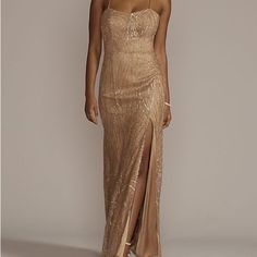 a woman wearing a gold dress with a slit down the side and one leg in front