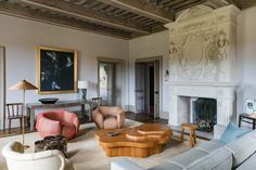 a living room filled with furniture and a fire place in front of a painting on the wall