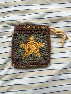 a crocheted square with a yellow star on it sitting on top of a bed