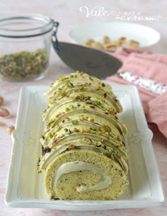 a white plate topped with a roll covered in frosting