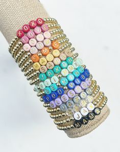 a stack of bracelets with letters on them