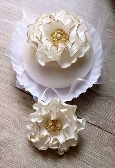 two white and gold flowers sitting on top of each other