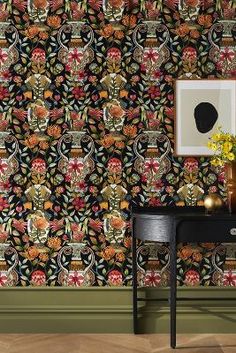 a black table with vases on top of it in front of a colorful wallpaper