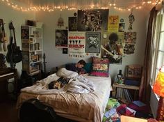 a bed room with a neatly made bed and lots of posters on the wall