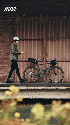 a man walking his bike down the street