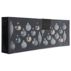 a black box with silver and white christmas ornaments in the shape of baubles