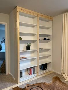 a living room filled with lots of white bookshelves