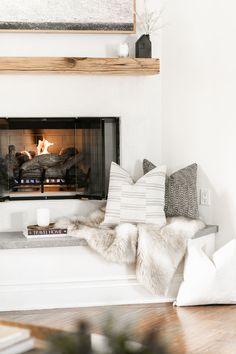 a living room with a fire place and pillows