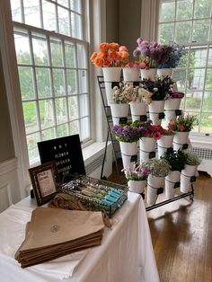 there are many flowers on display in the vases next to each other, along with books and magazines