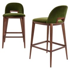 two green velvet bar stools with wooden legs and back rests against a white background