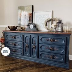 an old dresser is painted blue and decorated with wreaths, candles, and other decorations