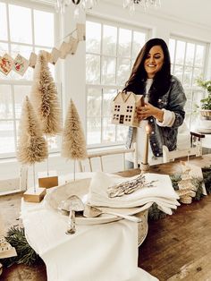 a woman standing in front of a table filled with christmas decorations