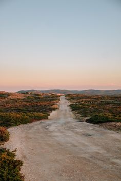 an empty dirt road in the middle of nowhere