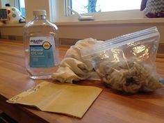 a bottle of water sitting on top of a wooden table next to a plastic bag