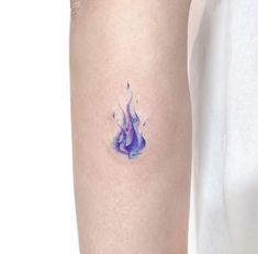 a woman's arm with a blue and purple tattoo design on the left forearm