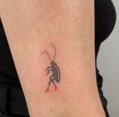 a small insect tattoo on the right upper arm and lower arm, with red feet