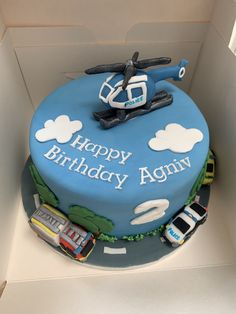 a blue birthday cake with a helicopter on top