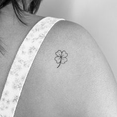 a woman with a four leaf clover tattoo on her shoulder