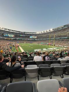 a football stadium filled with lots of people sitting on the bleachers and looking at their cell phones