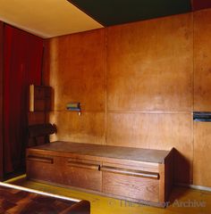 a room with wooden paneling and a bench