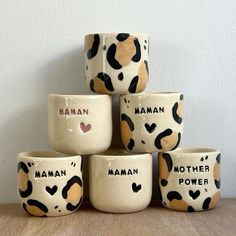 five ceramic bowls are stacked on top of each other with the words human, mother, power and hearts painted on them